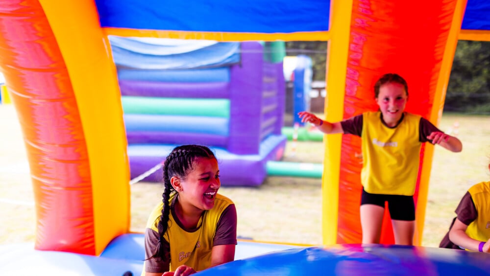 Two Brownies bouncing inside an inflatable bouncy castle