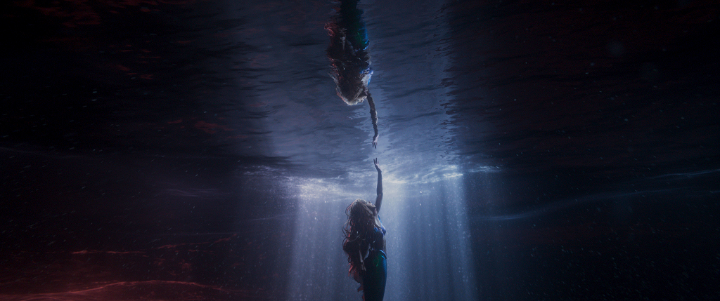 Underwater shot of mermaid Ariel reaching out towards the surface
